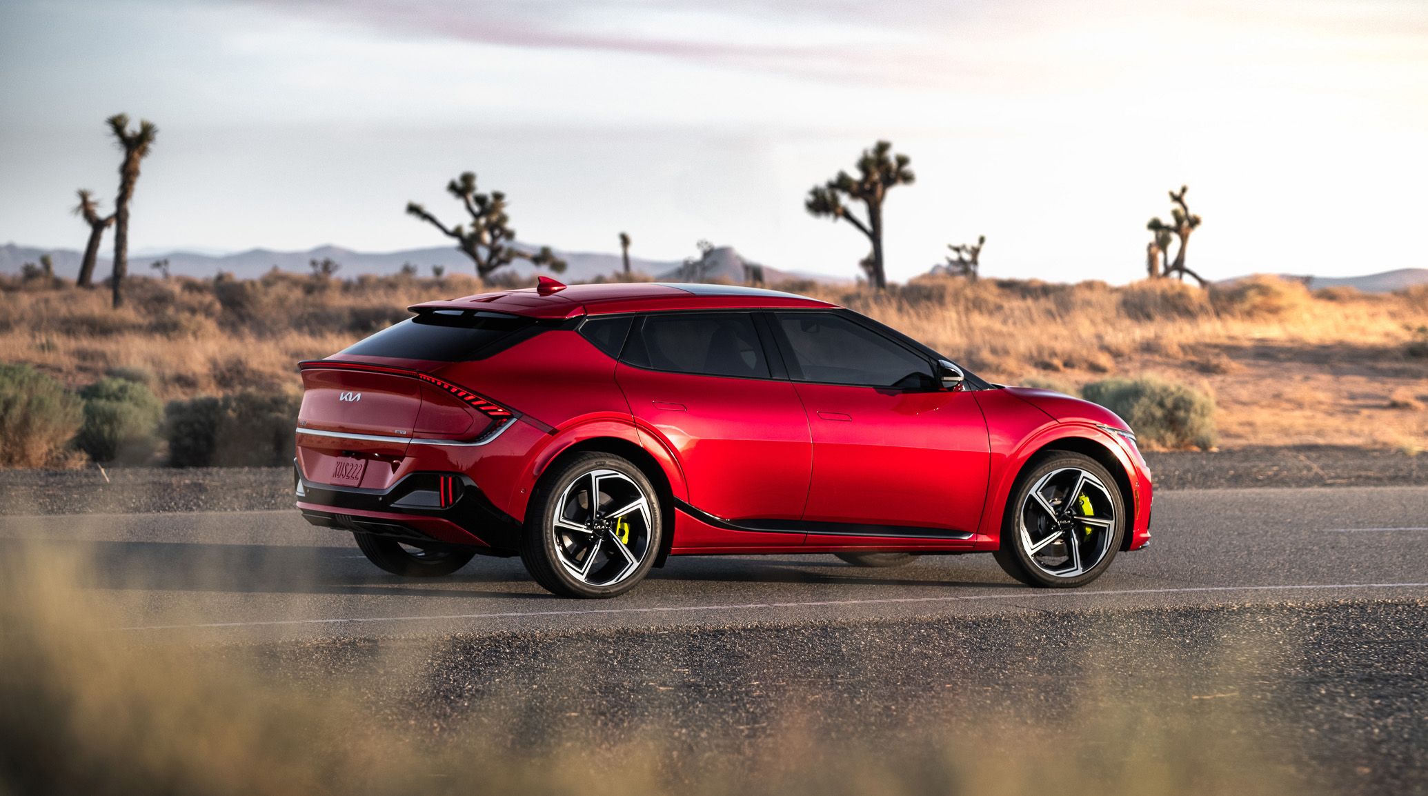 2024 Kia In Runway Red Parked On A Desert Road Side-View